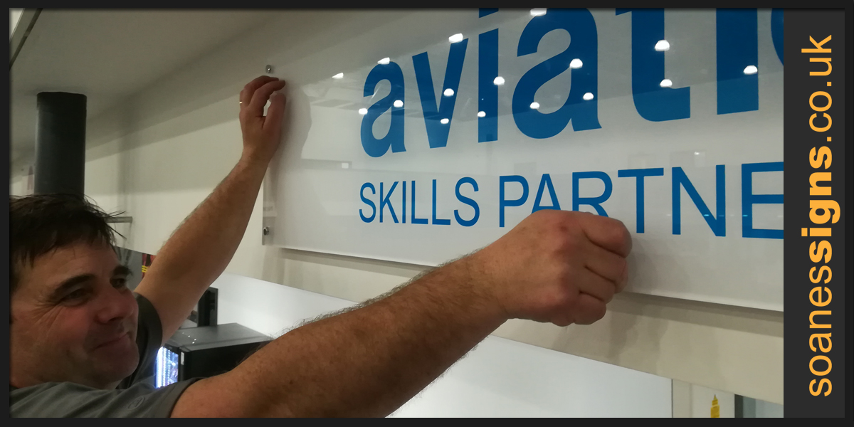 Acrylic signs on metal locators and off-stands reverse decorated with logo branding for sponsors of the International Aviation Academy Norwich