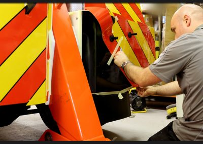 Applying reflective vinyl chevrons to the rear of Delmonte Recovery trucks